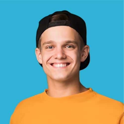 Smiling teen male with black hat on backgrounds and yellow shirt with aqua background.